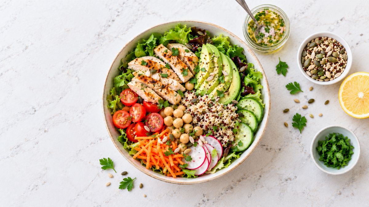Insalata completa con pollo grigliato, avocado, quinoa, ceci, pomodorini, cetrioli e verdure fresche